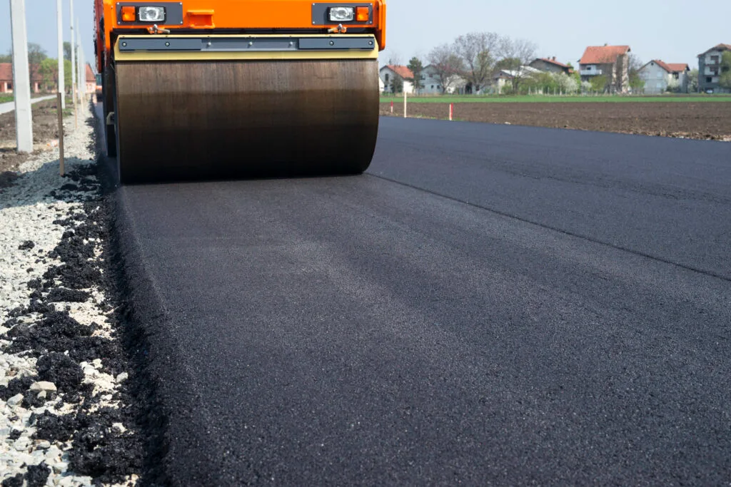 Chantier de construction routière avec rouleau compresseur, illustration de la pénurie de bitume